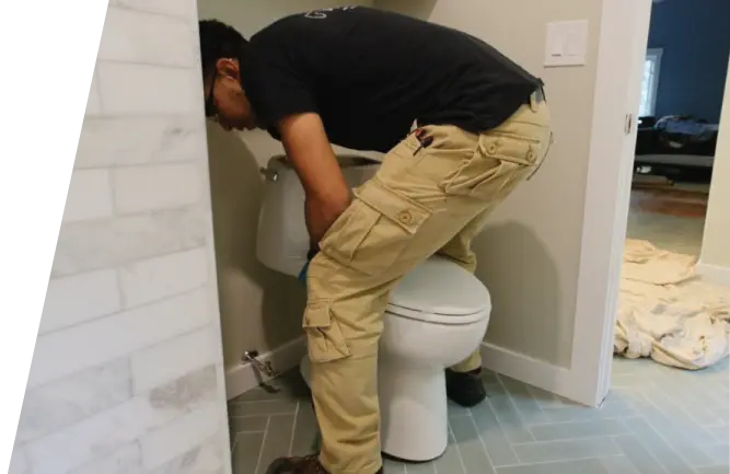 Plumber installing new toilet in bathroom